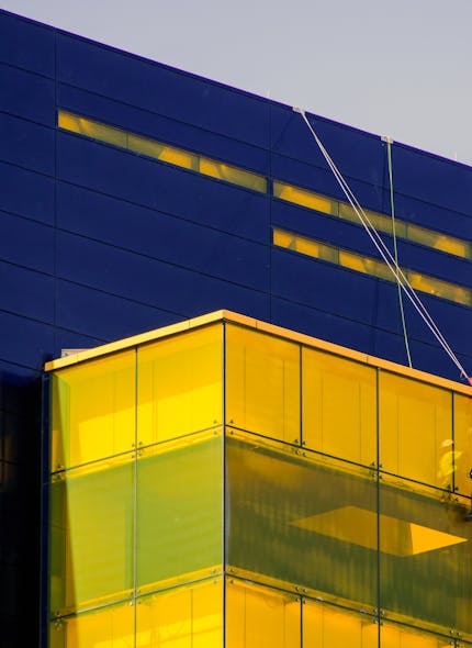 Modern navy building with a glowing gold glass corner — building ahead